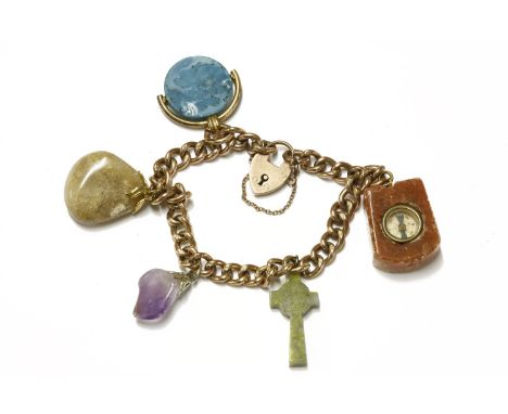 A gold curb link bracelet with padlock and assorted hardstone charms, including a rolled gold blue hardstone swivel fob, and 