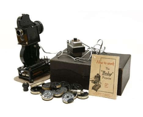 A French Pathe-Baby hand-cranked film projector in original case, with instruction manual and a quantity of baby film reels t