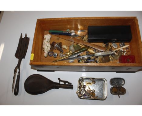 A wooden box containing various buttons, paper knife, various badges, leather and brass powder flask, a cased torch etc.