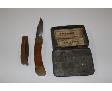 A vintage tin and contents of two pen knives and Treforest Mouldings Ltd. models of battleships and submarines with original 