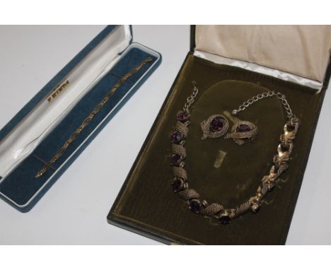 A boxed costume necklace set with amethyst coloured stones and matching ear-rings; and a 9ct gold bracelet, approx. 6gms 