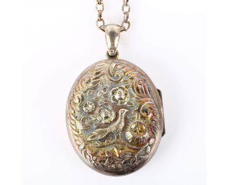 A Victorian sterling silver photo locket pendant necklace, relief embossed bird and floral decoration, on silver belcher link