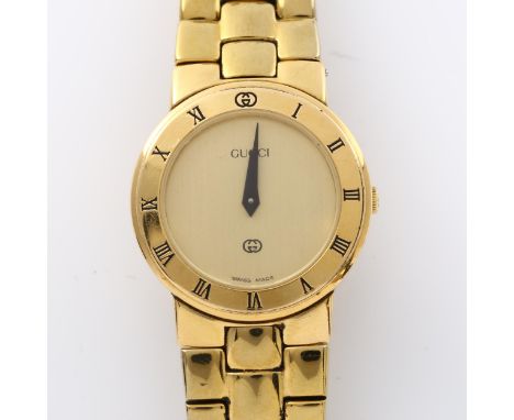 GUCCI - a lady's gold plated 3300L quartz bracelet watch, champagne dial with blue hands and Roman numeral chapter ring bezel