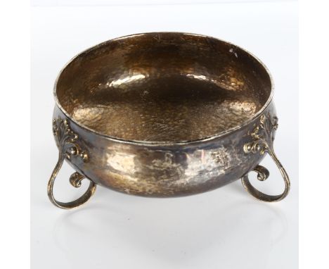 An Art Nouveau George V silver fruit bowl, allover hand planished decoration, with scrolled foliate feet and gilt interior, b