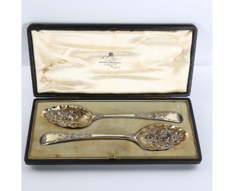 A pair of George III silver Old English pattern berry spoons, bright-cut engraved and relief embossed decoration with gilded 