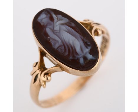 An early 20th century 9ct rose gold hardstone cameo ring, relief carved panel depicting female with closed-back settings, hal