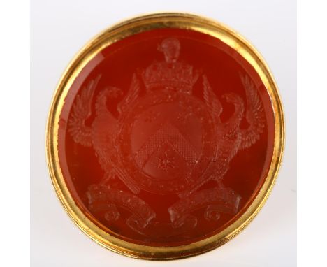 A large Victorian armorial seal fob, intaglio carved carnelian with Order Of The Bath motto "Tria Juncta In Uno" flanked by b
