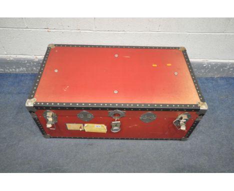 A RED LEATHERETTE RECTANGULAR TRAVELING TRUNK, with black plastic and studded banding, width 90cm x depth 51cm x height 35cm 