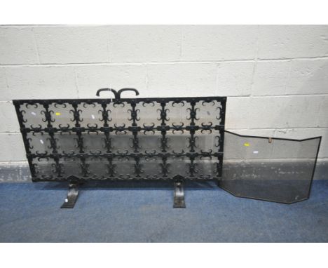 A WROUGHT IRON ECCLESIASTICAL FIRESCREEN, with a mesh backing, width 127cm x height 66cm and another fire screen (2)