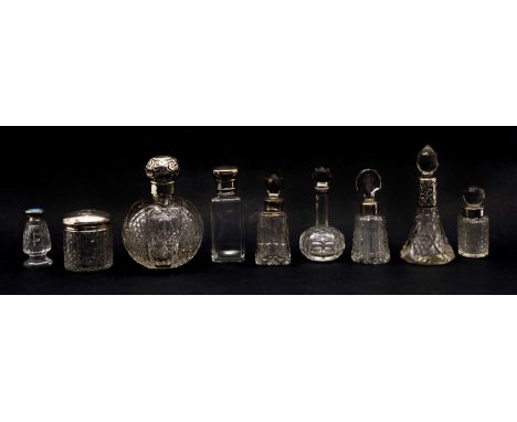 A collection of cut glass silver topped scent bottles, and other similar examples, to include a globular cut glass example, a