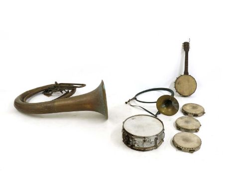 A collection of musical instruments, comprising a brass hunting horn, a sousaphone type instrument, a banjo mandolin, a snare