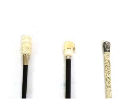 Three Ivory topped walking canes, 19th Century, the first with pomander handle with screw off top carved in relief with a sce
