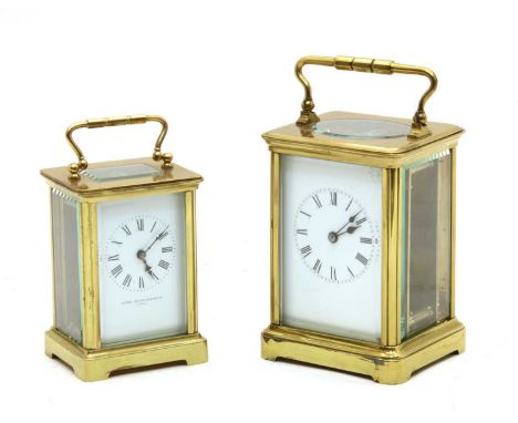 A French brass carriage timepiece, with enamel dial, Roman numerals, cased, together with a smaller example, the dial marked 