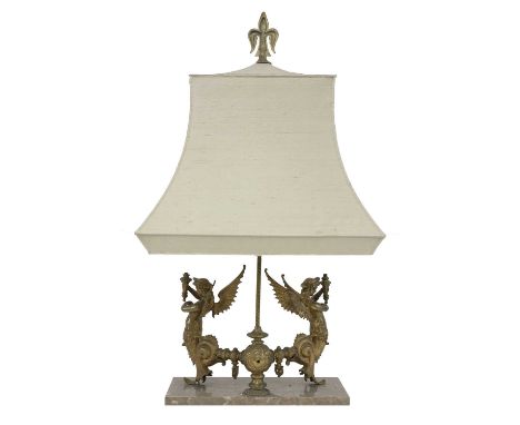 An ornate neoclassical style ormolu table lamp, mounted with a fleur-de-lys atop a cream shade, with a narrow spiral column o