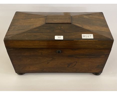 A 19th century rosewood tea caddy, of sarcophagus form, the hinged lid opening to a void interior, on compressed bun supports
