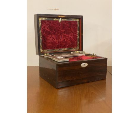 A 19th century rosewood and mother of pearl inlaid vanity box, the top lifting to reveal a toilet bottles and a well fitted a