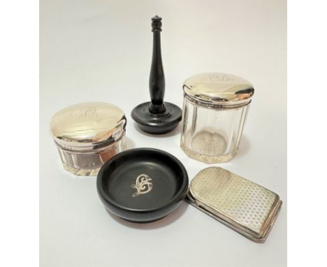 An ebonised turned column ring stand, (11.5cm x 6cm), an ebony pin dish mounted with white metal chased L, (d 6.5cm), a cryst