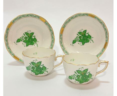 A pair of Herend Hungarian porcelain handpainted coffee cups with basket weave borders, decorated with green floral and gilt 