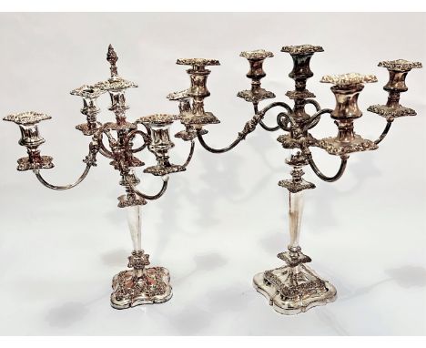 A near pair of Victorian style four branch Sheffield plated candelabra on knop and tapered stems with shaped bases, one with 