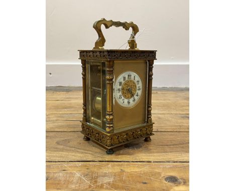 A Late 19th/ early 20th century gilt brass carriage clock, the four glass case with swing handle over bevel glazed viewing ap