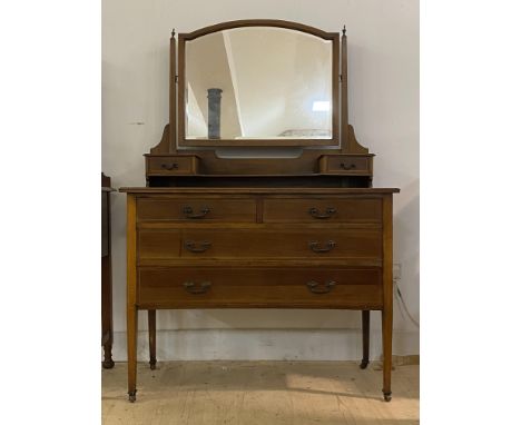 An Edwardian inlaid mahogany dressing table, the swing mirror over two trinket drawers and an open shelf, two short and two l