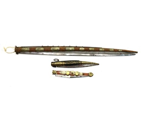 A large Spanish folding Navaja,late 19th century, with a sprung loaded 64cm single edged blade, the tapering brass covered ro