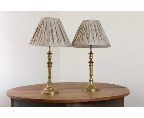 A pair of French Empire-style brass table lamps,of recent manufacture, each with a turned column support and with a grey plea