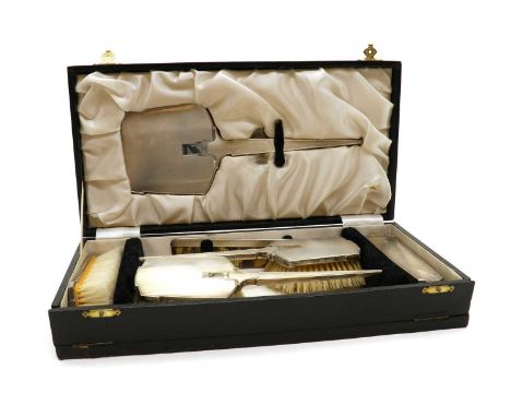 A silver dressing table set,by William Suckling Ltd, Birmingham 1941, comprising a hand mirror, 28cm long, two handheld brush