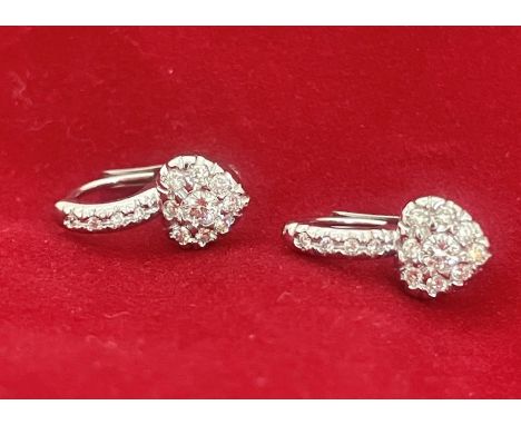 18kt white gold earrings with heart design set with small brilliant cut diamonds 0.35 ct. Crossbow closure. Weight: 3.8g.Indi