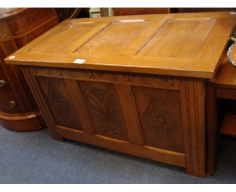 A REPRODUCTION LIGHT OAK COFFER with carved panels, 33" wide