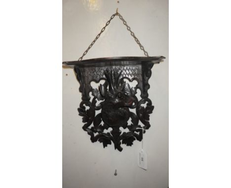 A BLACK FOREST CARVED WALL SHELF, depicting a stag's head