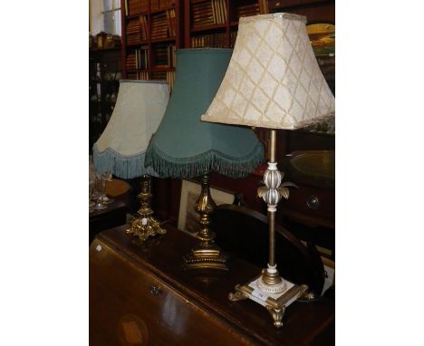 A GILT AND CREAM PAINTED TABLE LAMP and two others similar