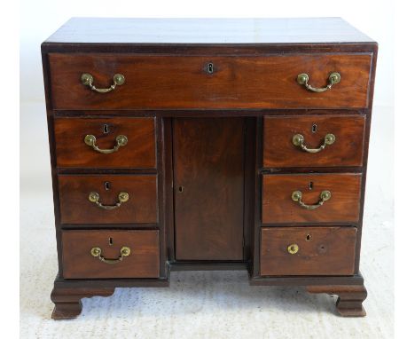 19th century mahogany kneehole desk with long drawer over cupboard flanked by three drawers on ogee bracket feet, h85 x w92 x