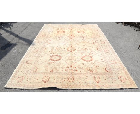 Agra carpet with palmettes and vine decoration on cream ground, within floral border, 414 x 312cm Condition Report:  Faded to