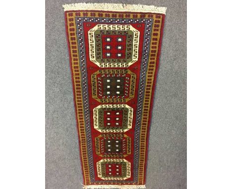 A fringed Persian design carpet runner