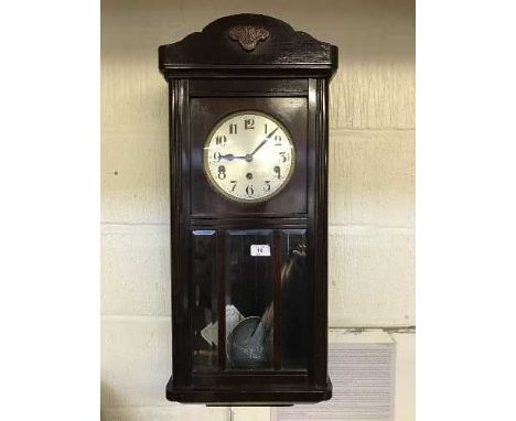 An early twentieth century wall clock with glazed panel door
