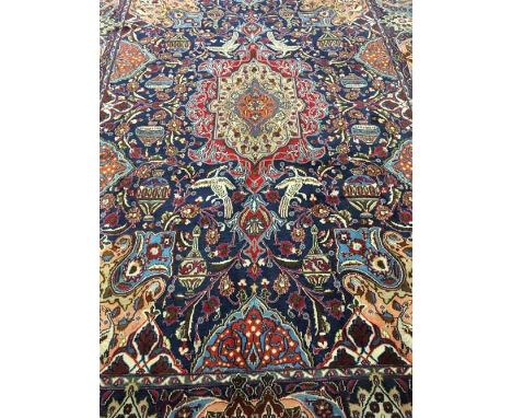 A fringed Persian carpet on blue ground