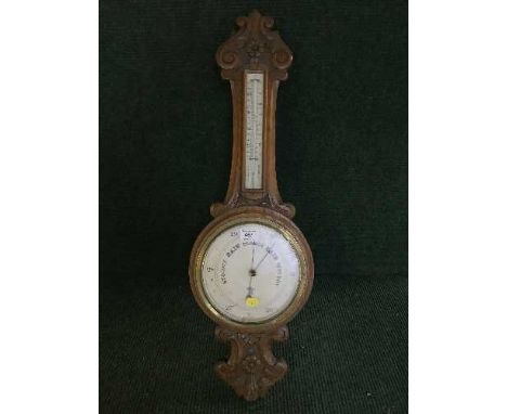 A carved oak barometer