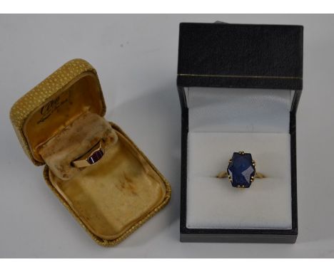 A small ruby set yellow gold ring, size (distorted) to/w a 9ct yellow gold ring set shaped blue stone (2)