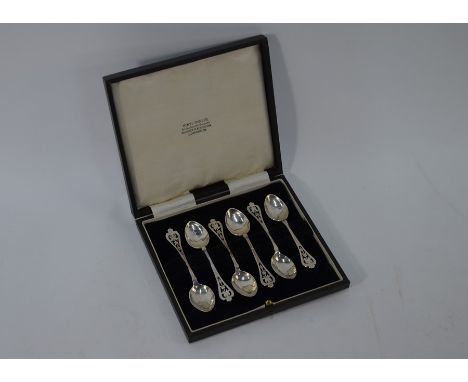 Sybil Dunlop - A set of six Arts &amp; Crafts silver coffee spoons with planished bowls and floral-pierced finials, London 19