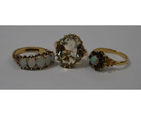 A five-stone opal ring, 9ct yellow gold set size L; a 9ct yellow gold opal and blue sapphire cluster ring, size N; and a ring