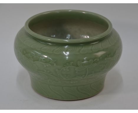 A Chinese celadon jardiniere of compressed baluster form with slightly everted rim, decorated with a wide band of peony scrol