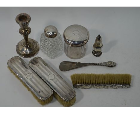 Two silver-mounted glass toilet jars, a silver-backed table brush, two haircombs, a silver-handled shoehorn, a loaded silver 