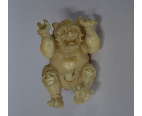 A Japanese 19th century carved ivory netsuke of an Oni wearing an animal skin loincloth, 5 cm highMissing digits from both ha