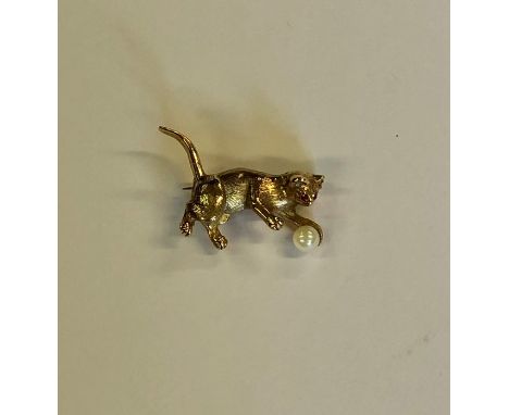 A 9ct yellow gold brooch in the form of a well-modelled cat with ruby-set eyes, chasing a pearl ball, 3 cm long approx 5.5g a