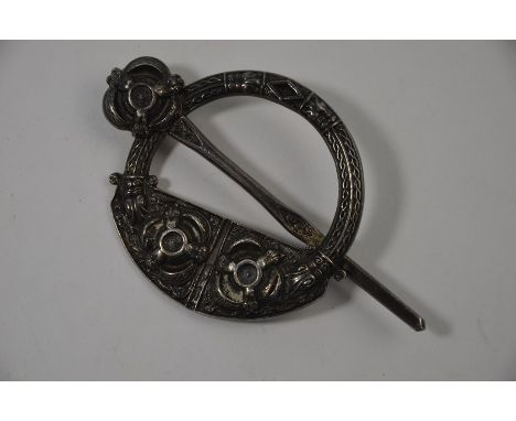 A Scottish style white metal cloak brooch featuring Celtic symbols in relief, 9 cm long