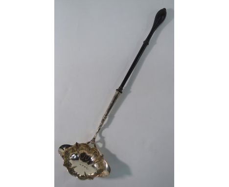 A George II silver punch ladle with double-lipped ogee bowl, on curved stem with shell mount and turned and ebonised handle, 