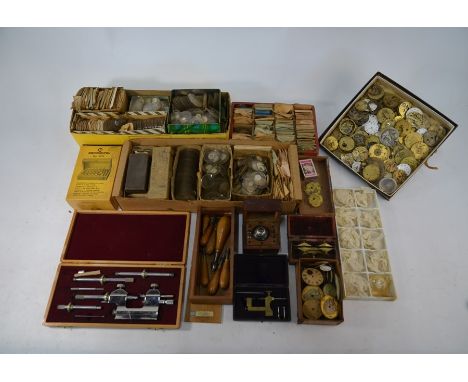A collection of vintage watchmakers' tools and findings, spares, movements and dials, glasses etc