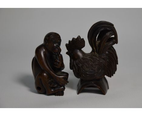 Two 20th century Japanese carved wood netsuke; a seated monkey holding a peach, 4.5 cm and a cockerel, 5.5 cm, each with inse