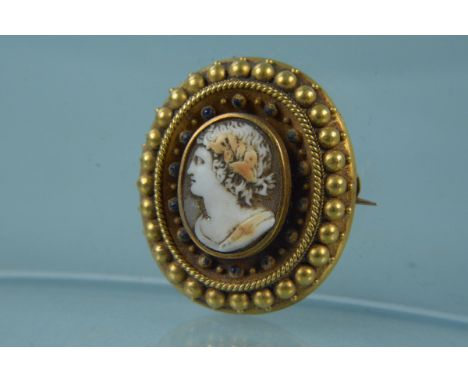A yellow metal mounted cameo brooch with blue enamel decoration